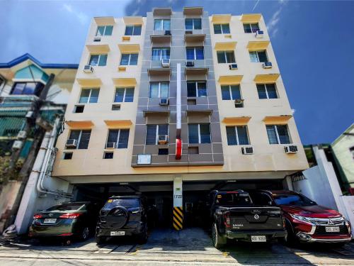 duży budynek z samochodami zaparkowanymi przed nim w obiekcie OYO 858 City Stay Inns Bgc Nuevo w mieście Manila