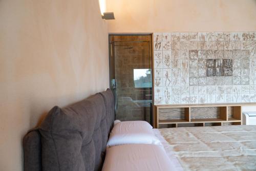 a bedroom with a bed and a glass shower at DONNAPAOLA MODERN FARM in Altamura