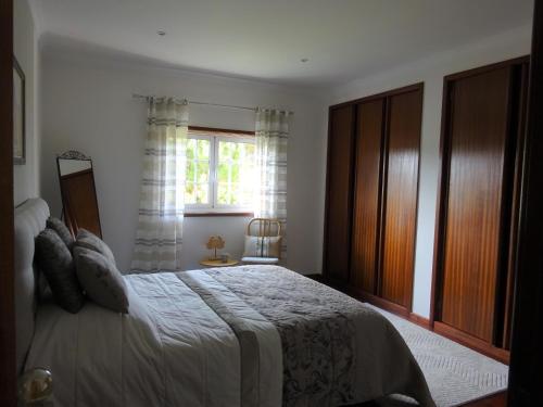 a bedroom with a large bed and a window at Ferienhaus Casa do mar mit seitlichem Meerblick in Vila Chã