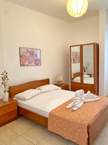 - une chambre avec un lit et un grand miroir dans l'établissement Delia Apartments, à Pefkohori