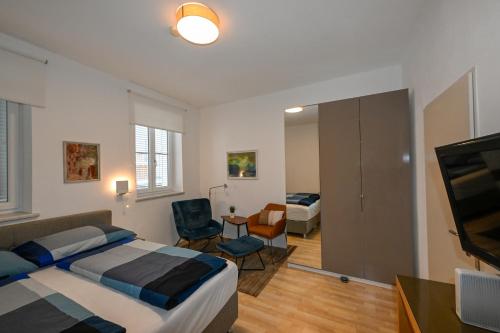 a bedroom with a bed and a room with a tv at Apartments Alter Platz in Klagenfurt
