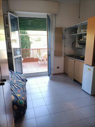 a kitchen with a door open to a patio at monolocale a un passo dal mare con parcheggio privato in Celle Ligure