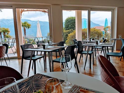 a restaurant with tables and chairs with a view at Garden Hotel Primavera in Brissago
