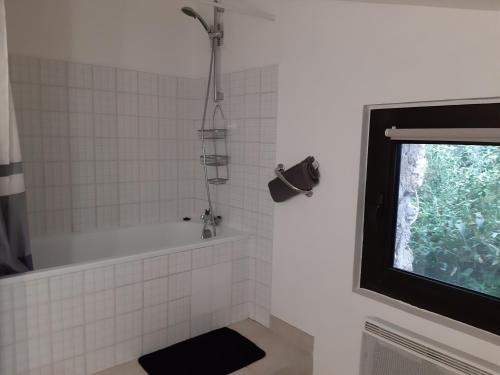 a bathroom with a bath tub and a television at Logis des Magnans -Les terrasses du Coutach - in Sauve