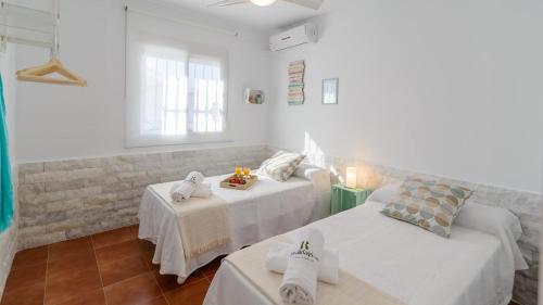 a white room with two beds and a table at Casa Serrano Cártama by Ruralidays in Cártama