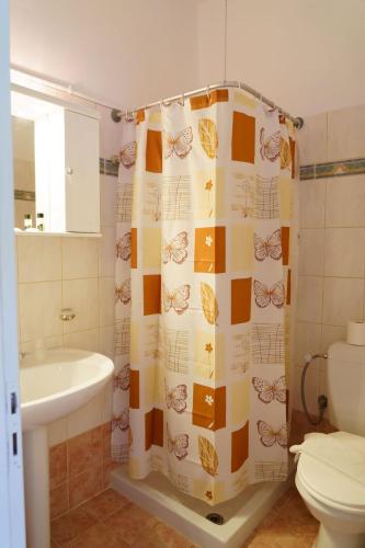 a bathroom with a shower curtain with butterflies on it at Residence La Scala in Parga