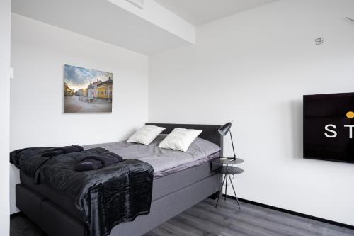 - une chambre avec un lit dans un mur blanc dans l'établissement Rauma City Center Studios, à Rauma
