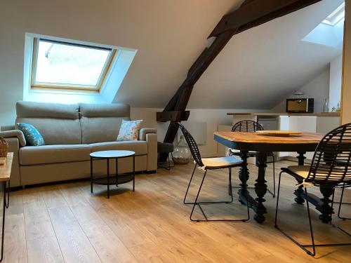 a living room with a couch and a table and chairs at Cocon en Champagne in Épernay