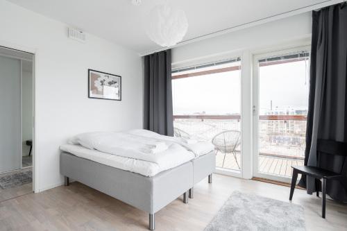 een slaapkamer met een bed en een groot raam bij 2ndhomes Tampere "Kaplan #1" Grand Luxury Apartment - Sauna & Balconies in Tampere