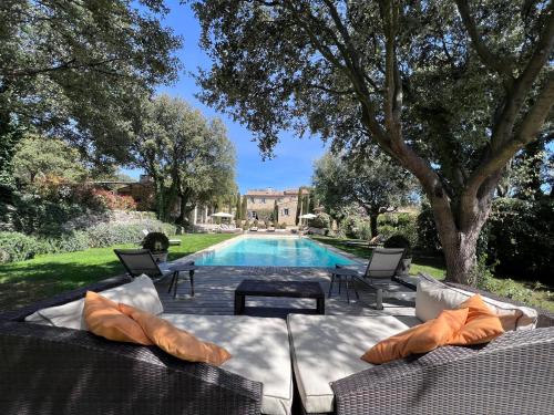a swimming pool with chairs and a table next to a house at Villa Hautvallon in Gordes