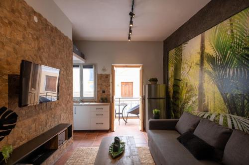 ein Wohnzimmer mit einem Sofa und einem TV in der Unterkunft Green Symi Apartment in Symi