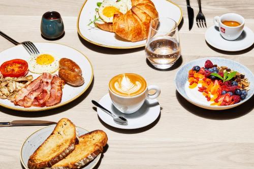 Una mesa con platos de desayuno y una taza de café. en Century City Hotel Bridgewater, en Ciudad del Cabo