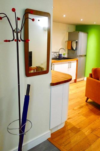 a kitchen with a mirror on a wall with a broom at “Dragons Den” Centrally located Modern Apartment in Aberystwyth