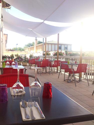 - une table avec de l'argenterie et des verres à vin sur la terrasse dans l'établissement Logis Hôtels - Hôtel et Restaurant Les Cordeliers, à Casteljaloux