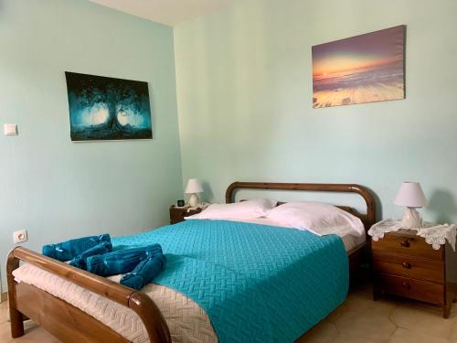 a bedroom with a bed with a blue comforter at Relaxation, Nature and Sea Near the Airport! in Artemida