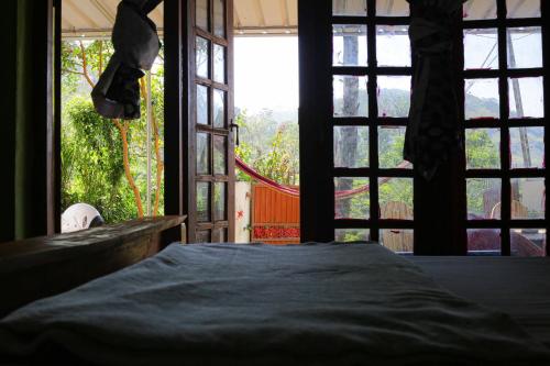 a bedroom with a bed in front of a window at HOME HOSTEL ELLA private rooms only in Ella