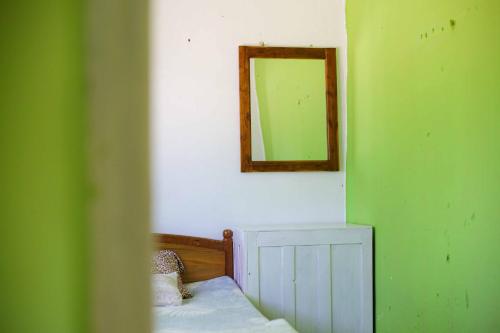 a room with a mirror on the wall and a bed at HOME HOSTEL ELLA private rooms only in Ella