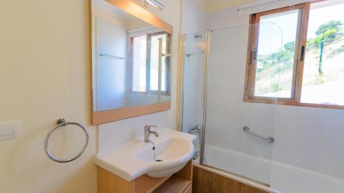 La salle de bains est pourvue d'un lavabo, d'une douche et d'un miroir. dans l'établissement Casa El Cerrillo Cómpeta by Ruralidays, à Cómpeta
