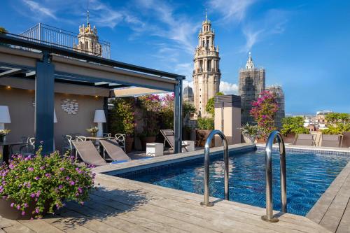 a pool on the roof of a building with a view of the city at Duquesa Suites Barcelona in Barcelona
