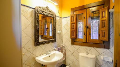 a bathroom with a sink and a mirror and a toilet at Casa El Secanillo Loja by Ruralidays in Loja