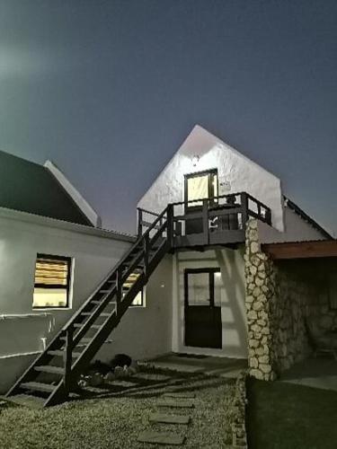 a white house with a staircase on the side of it at De Loft in Jacobs Bay