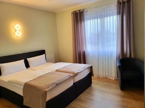 1 dormitorio con 2 camas y ventana en Lutz Motel, en Paderborn