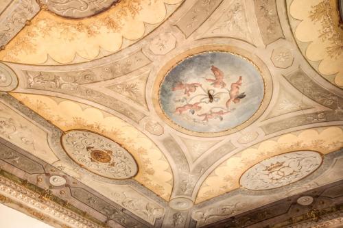 a ceiling in a building with a painting on it at Martius Private Suites Hotel in Rome