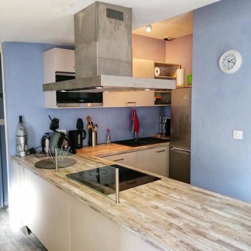 une cuisine avec un comptoir et une horloge murale dans l'établissement Le Petit Nicolas et Parking, à La Rochelle