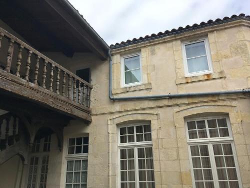 a stone building with windows and a balcony at Le Petit Nicolas in La Rochelle