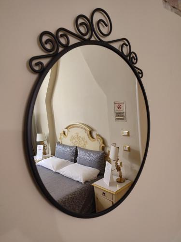 a mirror reflecting a bedroom with a bed in it at Casa Aurora in Ravenna