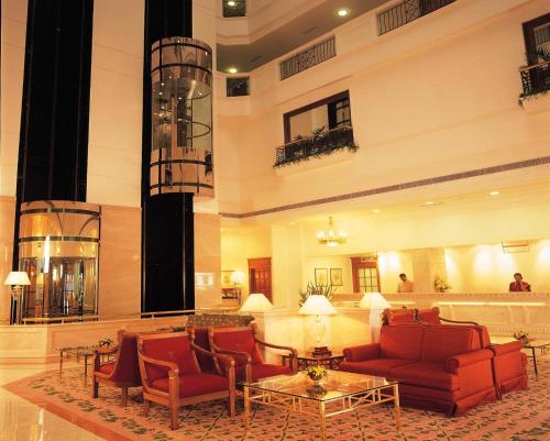 a lobby with couches and tables in a building at Abad Atrium in Cochin