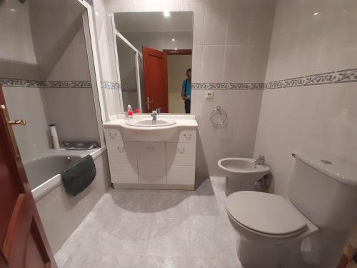 a bathroom with a white toilet and a sink at Con vistas al mar y aparcamiento gratis in Suances