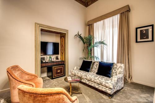a living room with a couch and a chair at Martius Private Suites Hotel in Rome