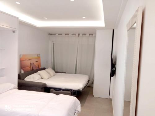 um pequeno quarto com 2 camas e um sofá em Apartamento Perla Costa del Sol em Fuengirola