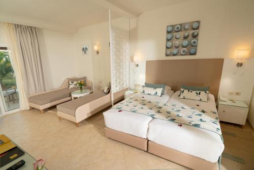 a large bedroom with a large bed and a couch at TUI MAGIC LIFE Penelope Beach - Families & Couples in Midoun