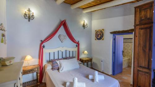 een slaapkamer met een bed en een bad in een kamer bij Casa Tejeda Frigiliana by Ruralidays in Frigiliana