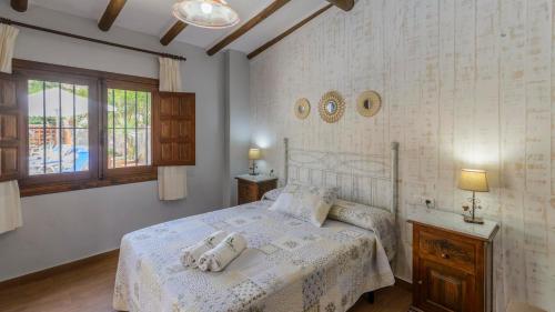a bedroom with a bed with two towels on it at Cortijo Las Revueltas Molvízar by Ruralidays in Granada