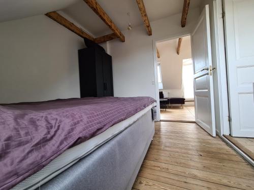 um quarto com uma cama com um edredão roxo em Aarhus Penthouse em Arhus