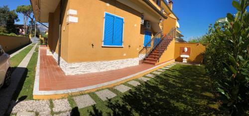 a house with a brick walkway and a blue window at Casa Vacanze Sunflower in Carrara