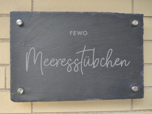 a sign on the side of a brick wall with the word herselfilda at Gemütliches Meeresstübchen, zentrums- und hafennah in Neustadt in Holstein