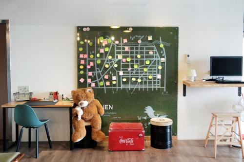 a teddy bear sitting at a desk in a classroom at Light Hostel Hualien in Hualien City