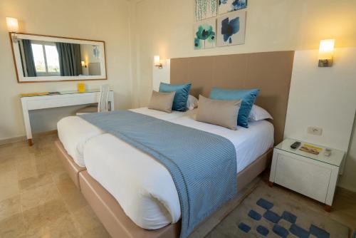 a bedroom with a large bed with blue pillows at TUI MAGIC LIFE Penelope Beach - Families & Couples in Midoun