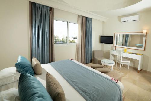 a bedroom with a bed and a desk in a room at TUI MAGIC LIFE Penelope Beach - Families & Couples in Midoun
