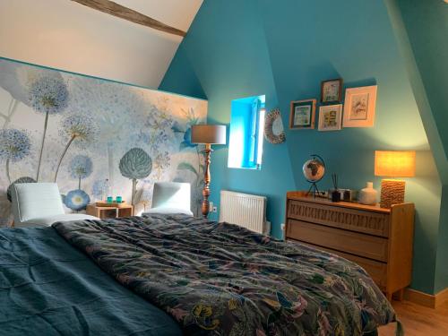 a bedroom with a bed and a blue wall at L’En Vert du Monde in Saint-Boil