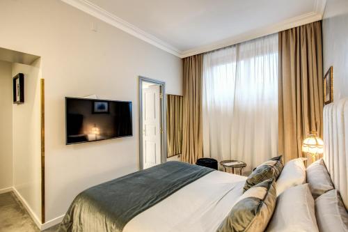 a hotel room with a bed and a flat screen tv at Martius Private Suites Hotel in Rome