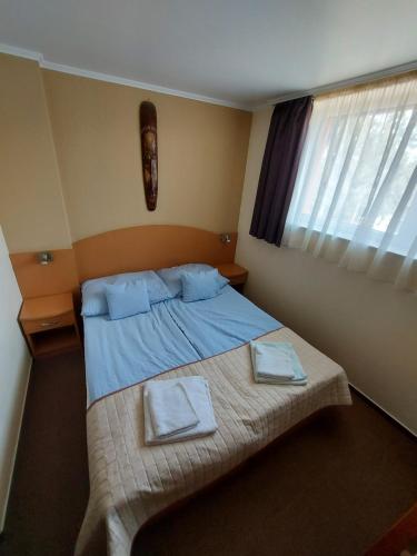 een slaapkamer met een bed met twee handdoeken erop bij Szepi Fogadó Szendehely in Szendehely