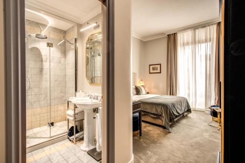 a bedroom with a bed and a sink and a shower at Martius Private Suites Hotel in Rome