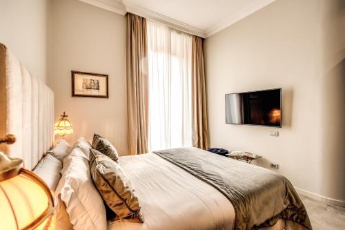 a hotel room with a bed and a television at Martius Private Suites Hotel in Rome