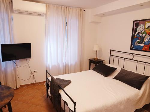 a bedroom with a bed and a flat screen tv at Jerry & Oli's Apartments in Šibenik