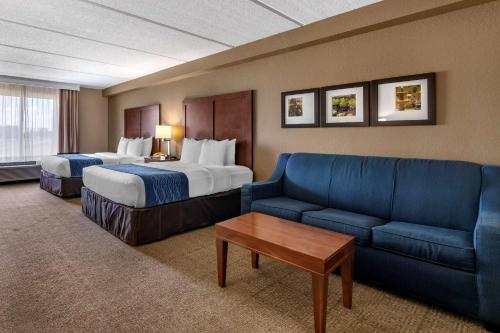 a hotel room with two beds and a couch at Comfort Inn & Suites Orlando North in Sanford